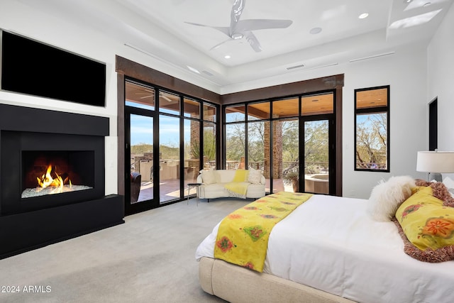 carpeted bedroom with a towering ceiling, access to outside, and ceiling fan