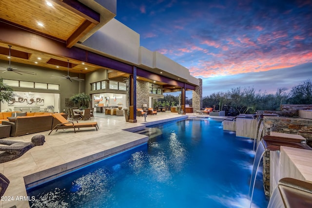 pool at dusk featuring a patio area, outdoor lounge area, pool water feature, and ceiling fan