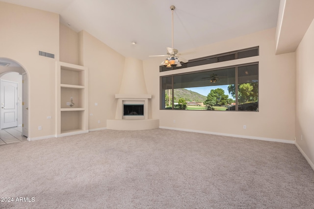 unfurnished living room with ceiling fan, light carpet, lofted ceiling, and a fireplace