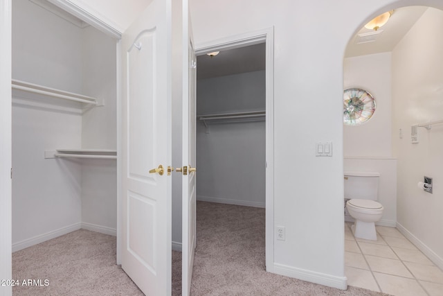 bathroom featuring toilet and tile patterned flooring