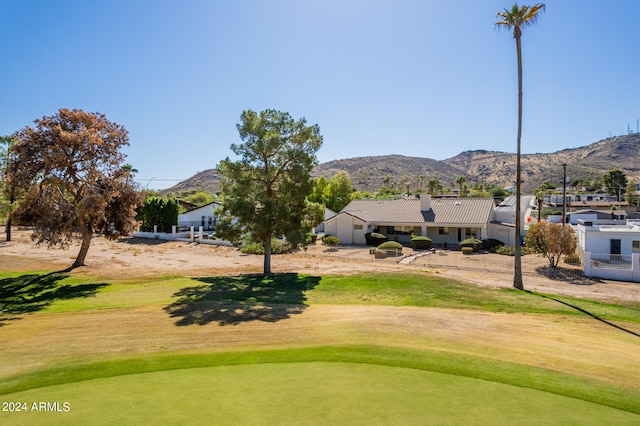 surrounding community with a mountain view and a lawn