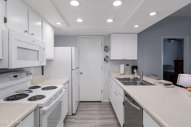 kitchen with light countertops, white appliances, a sink, and white cabinetry