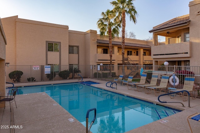 community pool featuring fence and a patio