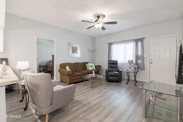 living room featuring light wood finished floors, ceiling fan, and baseboards