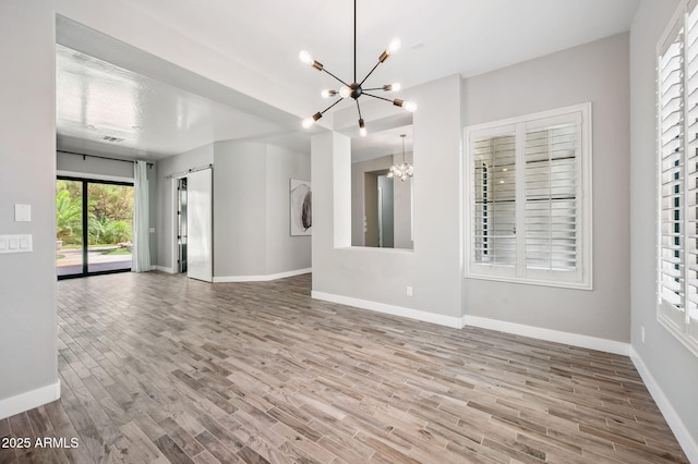 422 E Kaibab Pl, Chandler, AZ 85249 - unfurnished living room featuring a chandelier, wood finished floors, and a barn door