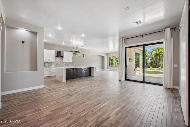 422 E Kaibab Pl, Chandler, AZ 85249 - unfurnished living room featuring light wood-type flooring, arched walkways, and recessed lighting