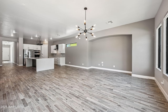 422 E Kaibab Pl, Chandler, AZ 85249 - unfurnished living room featuring a chandelier and light wood finished floors