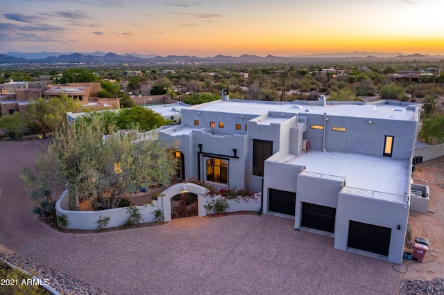 view of front facade with a garage, a mountain view, and stucco siding