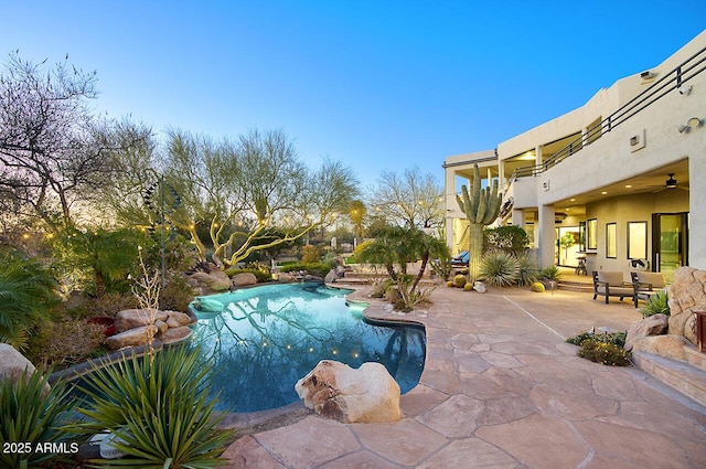 outdoor pool featuring a patio area and a ceiling fan