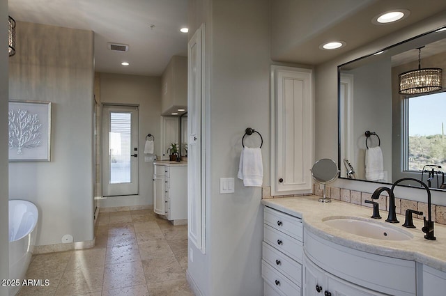 full bath with recessed lighting, a freestanding tub, vanity, and baseboards