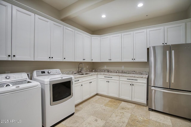 clothes washing area featuring recessed lighting, stone finish flooring, a sink, separate washer and dryer, and laundry area