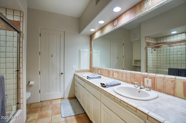 full bath with double vanity, visible vents, toilet, and a sink