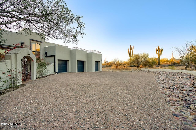 view of front facade featuring driveway, a garage, and stucco siding