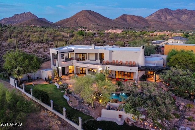 rear view of house featuring a mountain view, a patio area, a fenced backyard, and a balcony