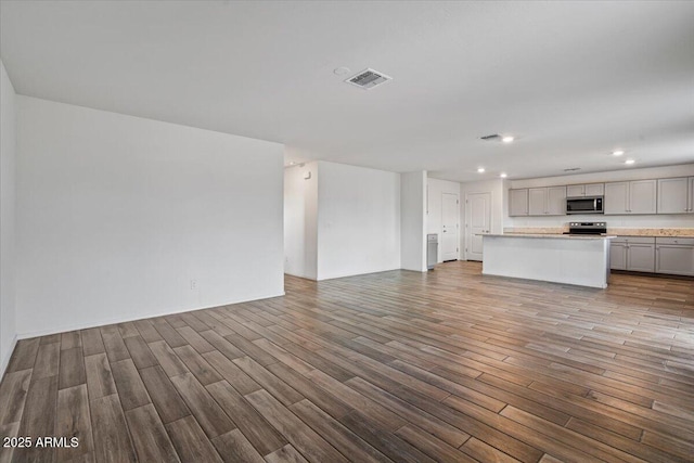 unfurnished living room with wood finished floors, visible vents, and recessed lighting