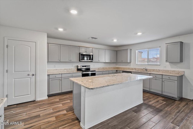 618 E Elm Ln, Avondale, AZ 85323 - kitchen with gray cabinetry, stainless steel appliances, a sink, visible vents, and dark wood finished floors