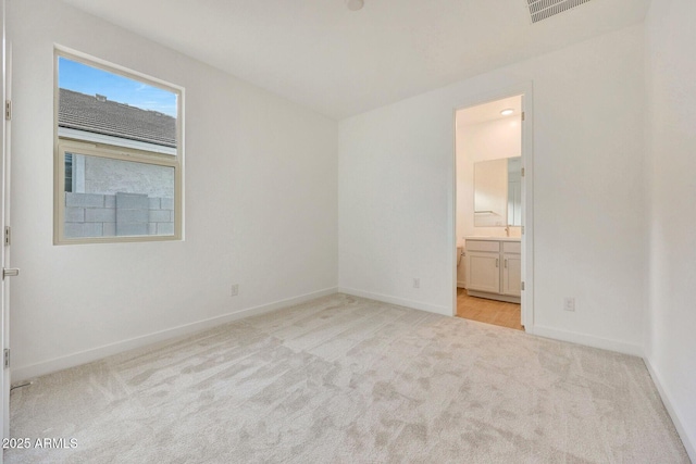 unfurnished bedroom featuring connected bathroom, carpet, visible vents, and baseboards