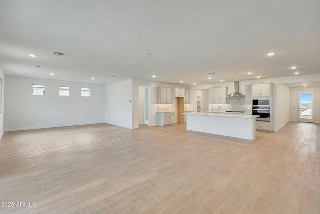 interior space with recessed lighting, light wood-style floors, and visible vents