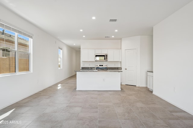 kitchen featuring visible vents, recessed lighting, a kitchen island with sink, stainless steel appliances, and white cabinetry