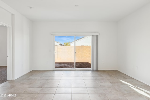 empty room with light tile patterned floors and baseboards