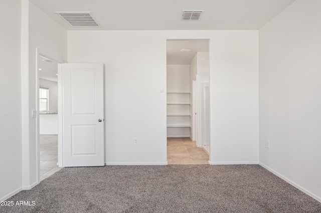 unfurnished bedroom featuring baseboards, visible vents, and carpet floors