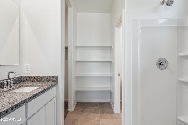 full bath featuring vanity, tile patterned floors, a shower, and baseboards