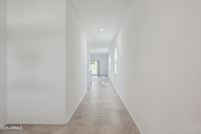 hallway with baseboards and light tile patterned flooring