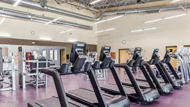 workout area featuring visible vents and a towering ceiling