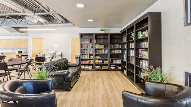 living area with recessed lighting, light wood-style floors, and concrete block wall