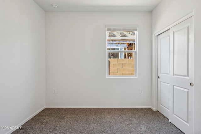 unfurnished bedroom featuring baseboards and carpet