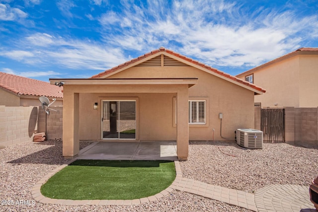 back of property with stucco siding, central AC, a tile roof, and a fenced backyard