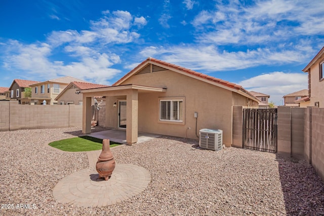 rear view of house featuring a patio, central air condition unit, a fenced backyard, a gate, and stucco siding