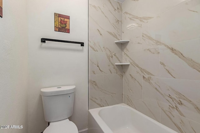 bathroom featuring toilet and tiled shower / bath