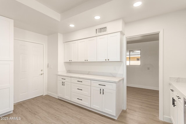 kitchen with light hardwood / wood-style flooring and white cabinets