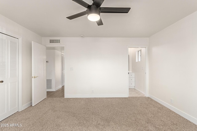 unfurnished bedroom with ceiling fan, light colored carpet, connected bathroom, and a closet