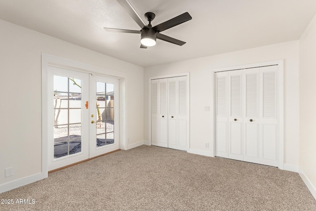 unfurnished bedroom featuring access to outside, french doors, multiple closets, and carpet