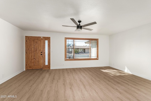 empty room featuring ceiling fan, a textured ceiling, and light hardwood / wood-style floors