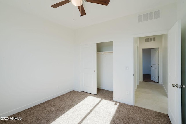 unfurnished bedroom featuring ceiling fan, a closet, and light carpet