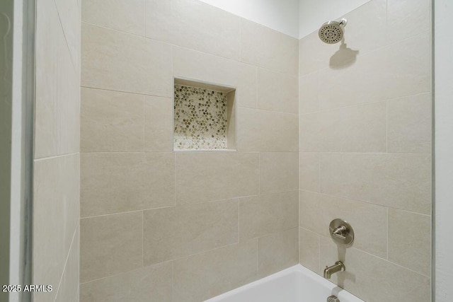 bathroom featuring tiled shower / bath