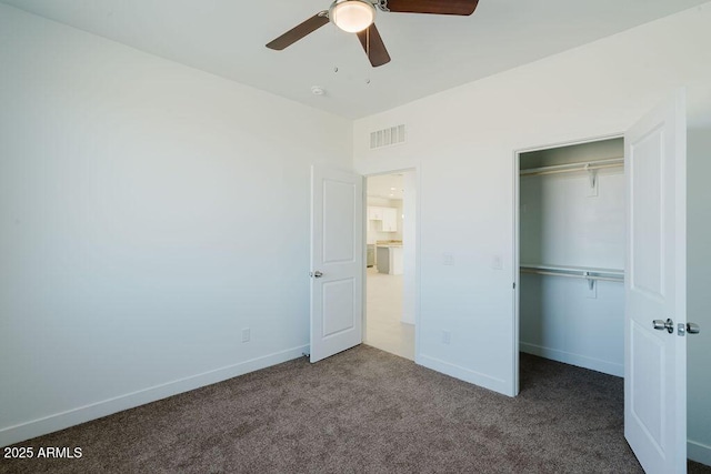 unfurnished bedroom with ceiling fan, a closet, and carpet