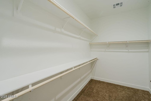 spacious closet featuring dark colored carpet