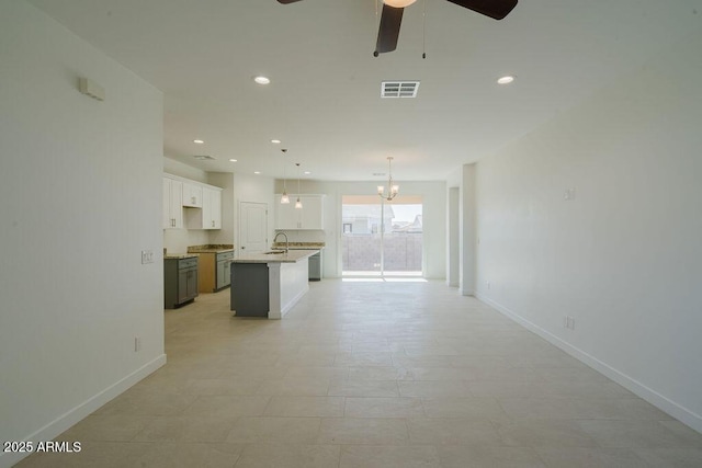 unfurnished living room with ceiling fan with notable chandelier and sink