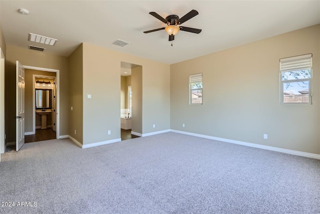 unfurnished bedroom with carpet, ensuite bath, and ceiling fan