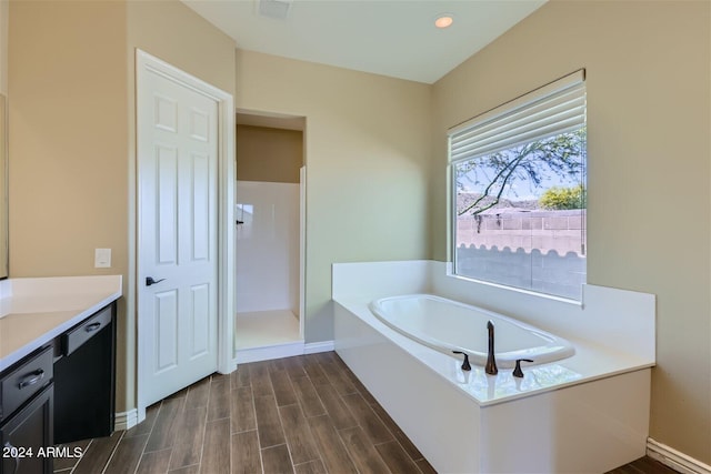 bathroom with a washtub and vanity