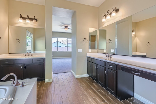 bathroom featuring double vanity, ceiling fan, and a bathing tub