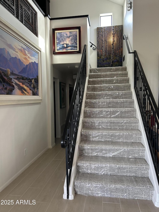 stairs featuring high vaulted ceiling