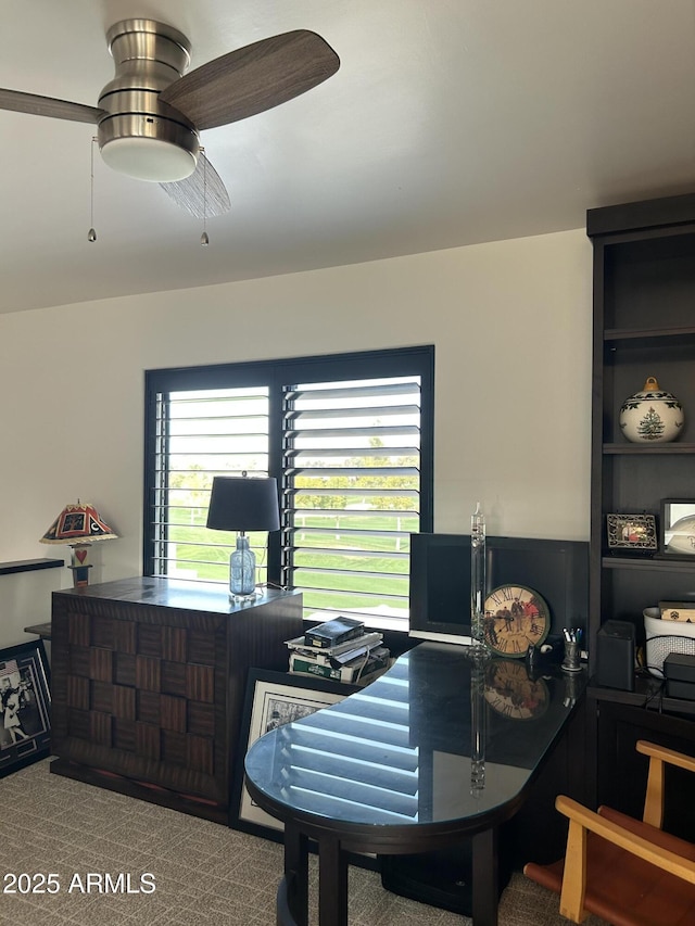 carpeted dining space with ceiling fan