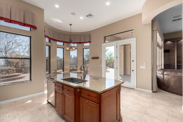 kitchen featuring a sink, visible vents, stainless steel dishwasher, brown cabinets, and light stone countertops