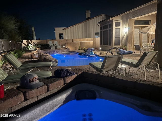 pool at twilight with a fenced backyard, a jacuzzi, a fenced in pool, and a patio