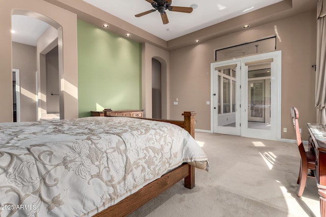 bedroom featuring arched walkways, access to outside, carpet flooring, and baseboards